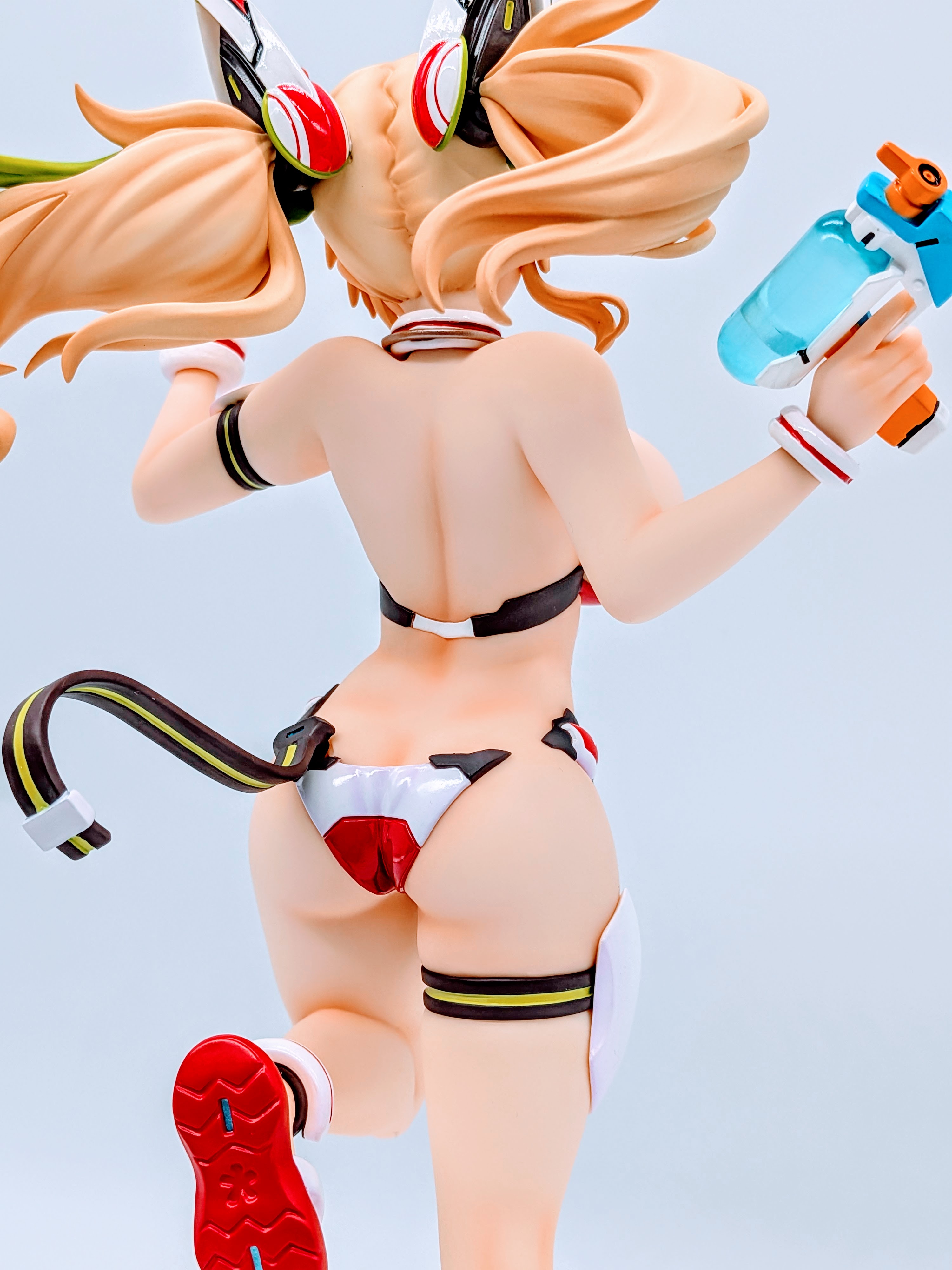 Low back angle of Sunshine Gene showing legs, swimsuit and clear base