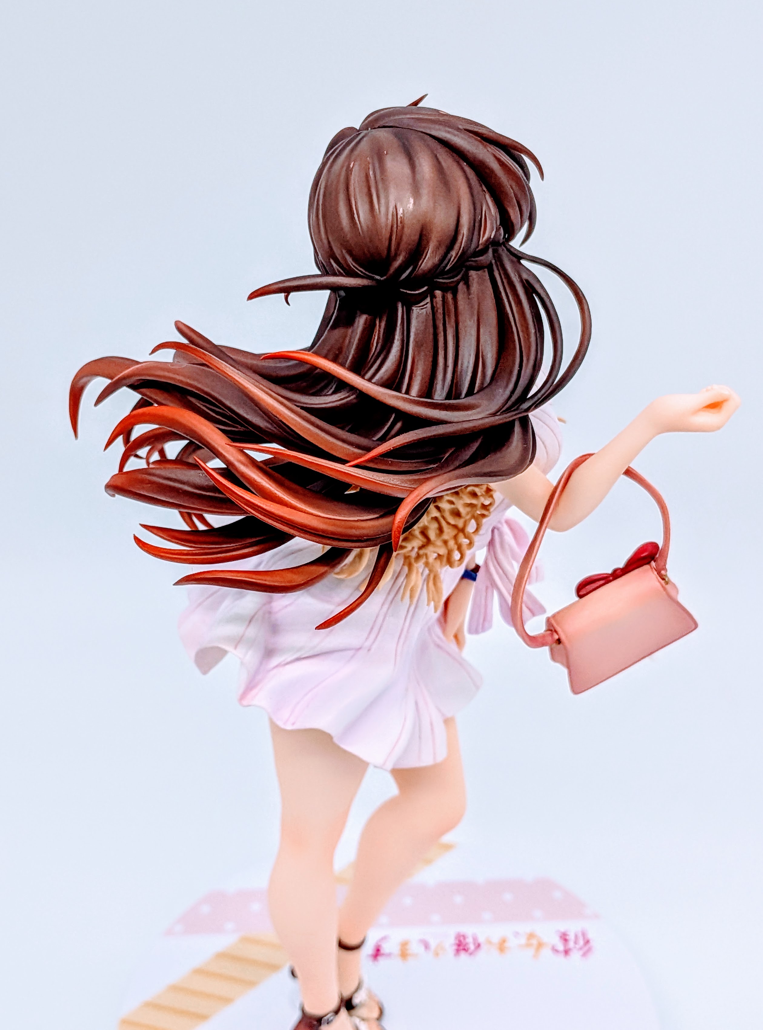 Upper back angle of Chizuru Mizuhara figure showing hair volume and hand on skirt