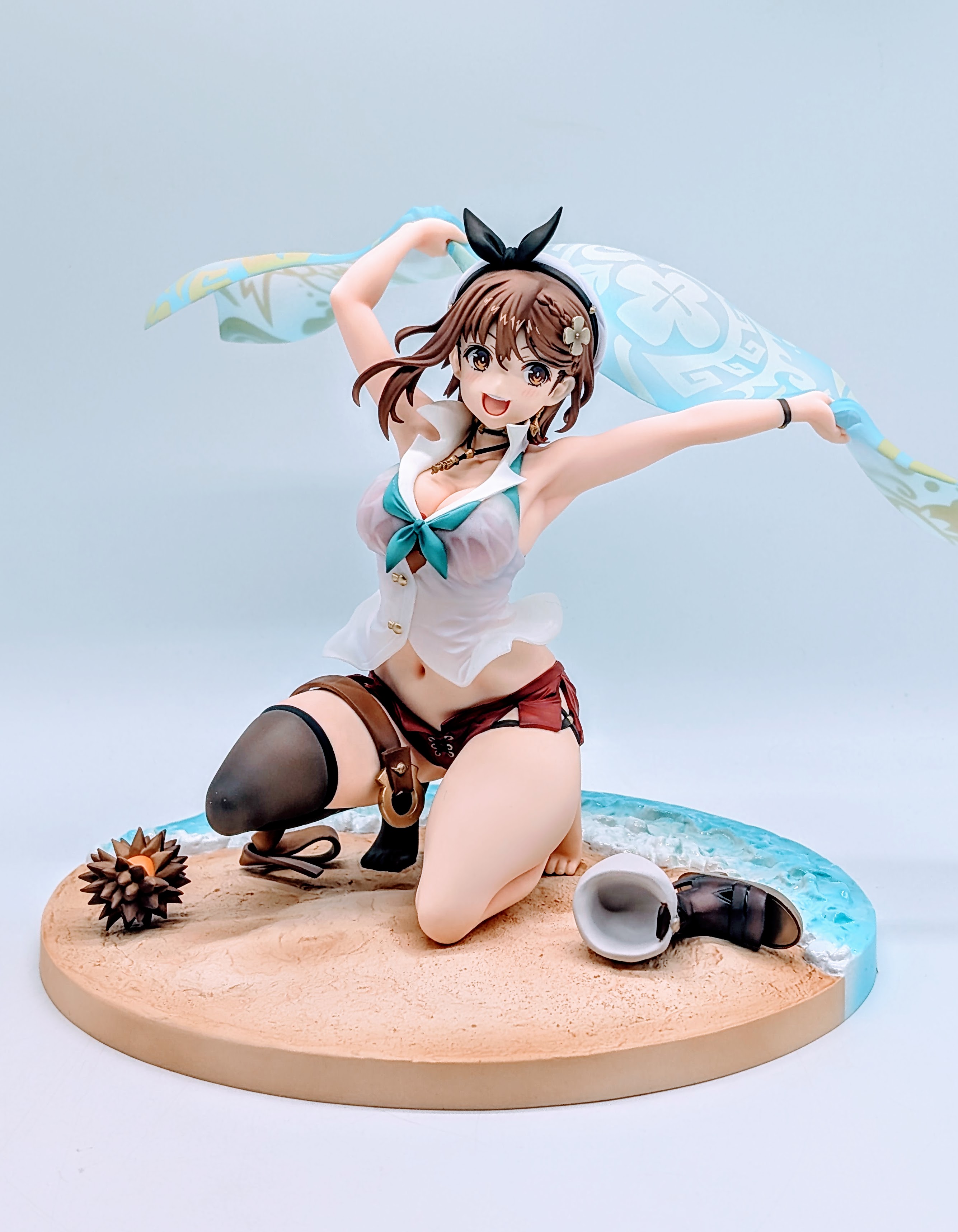 Full front view of Ryza beach figure kneeling on the sand base