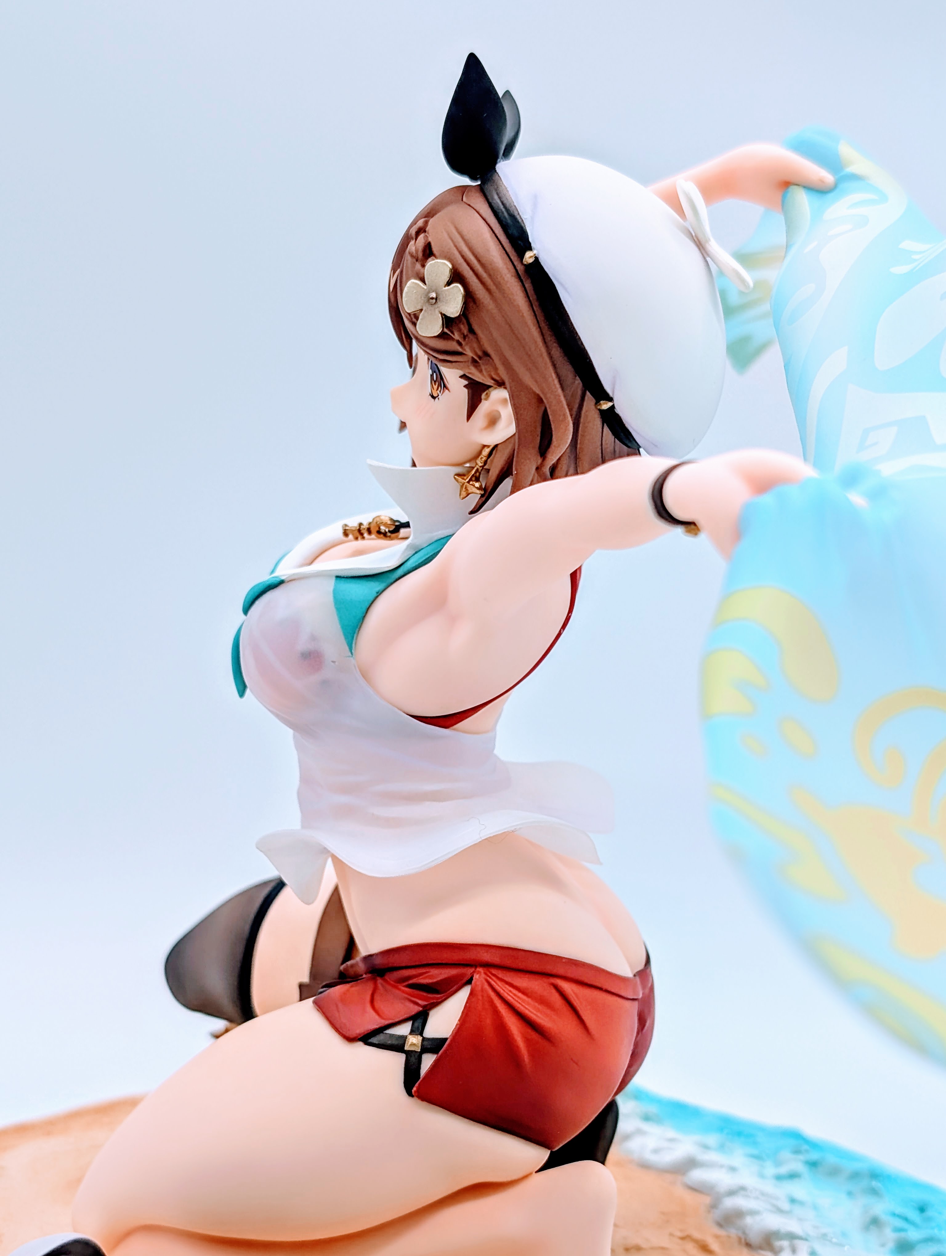 Side full-body view of Ryza kneeling with towel flowing behind her