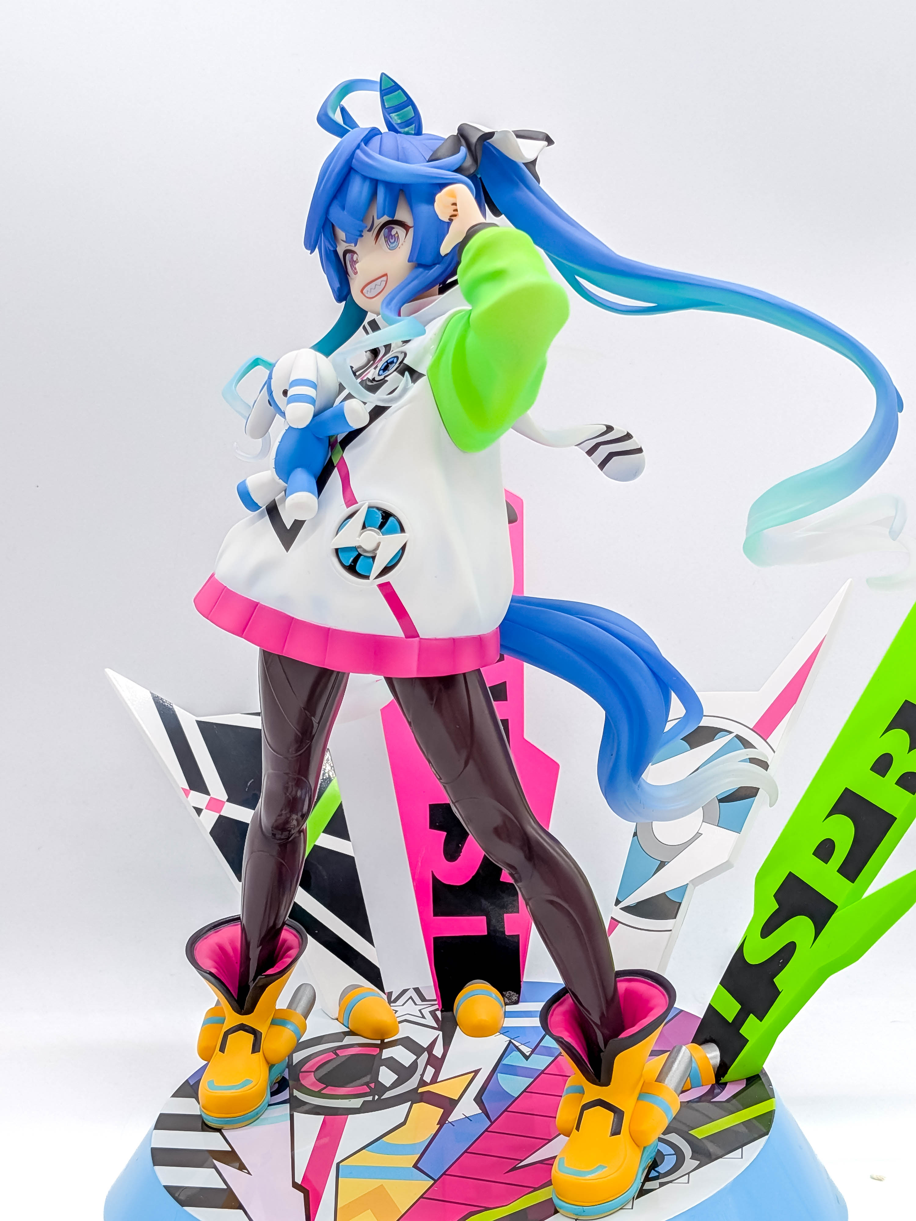 Twin Turbo figure full side view with long blue hair and colorful base
